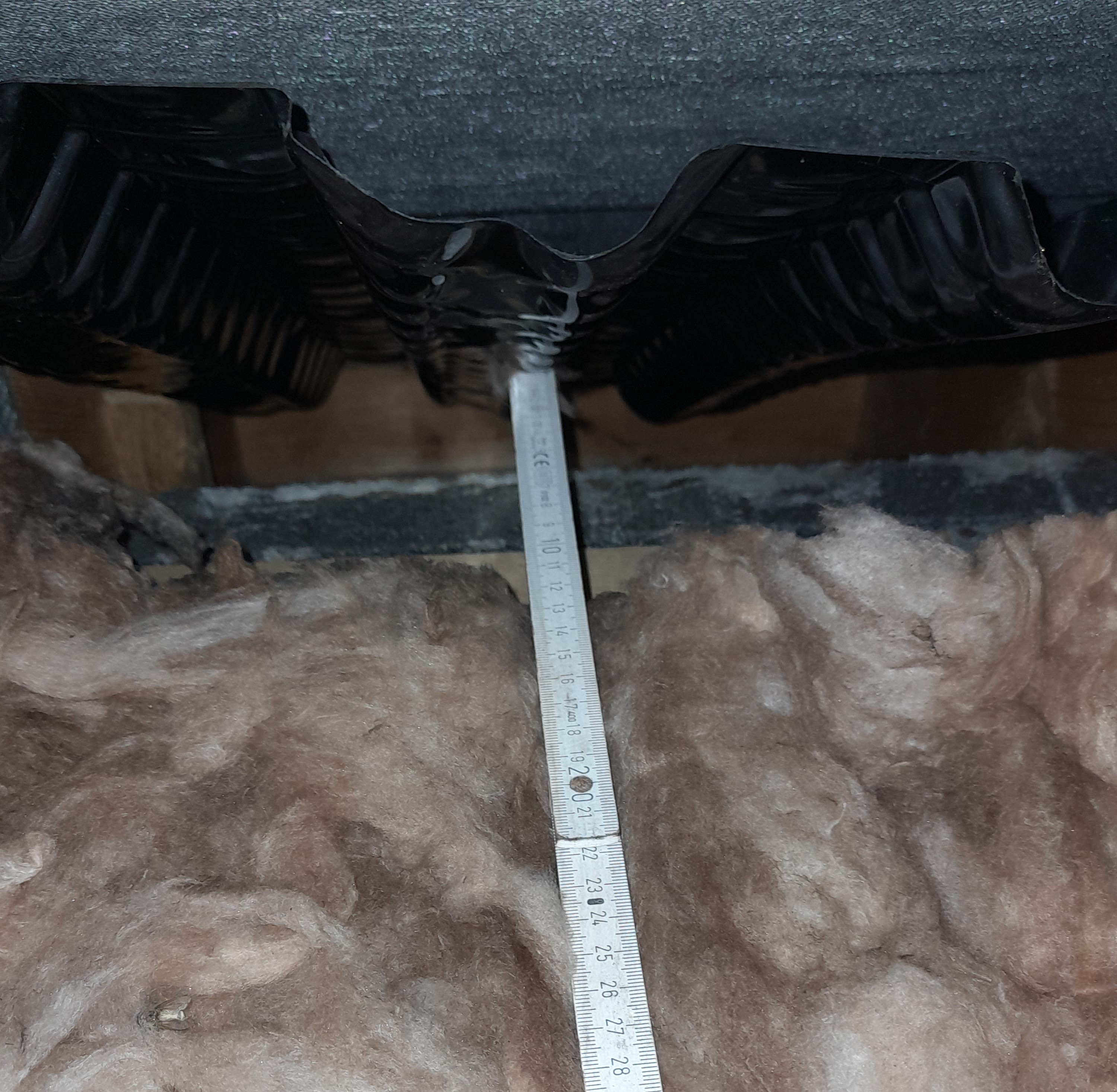 Fig. 3: Bottom layer of insulation at the eaves. Near the top of the image, the black plastic eaves ventilation tray is visible. Below this, in grey, is the inner leaf of blockwork. The insulation should be entirely covering the blockwork, pushed up snug against the eave’s ventilation tray. The blockwork is instead cold, which means water vapour is more likely to condense on it in the room below.